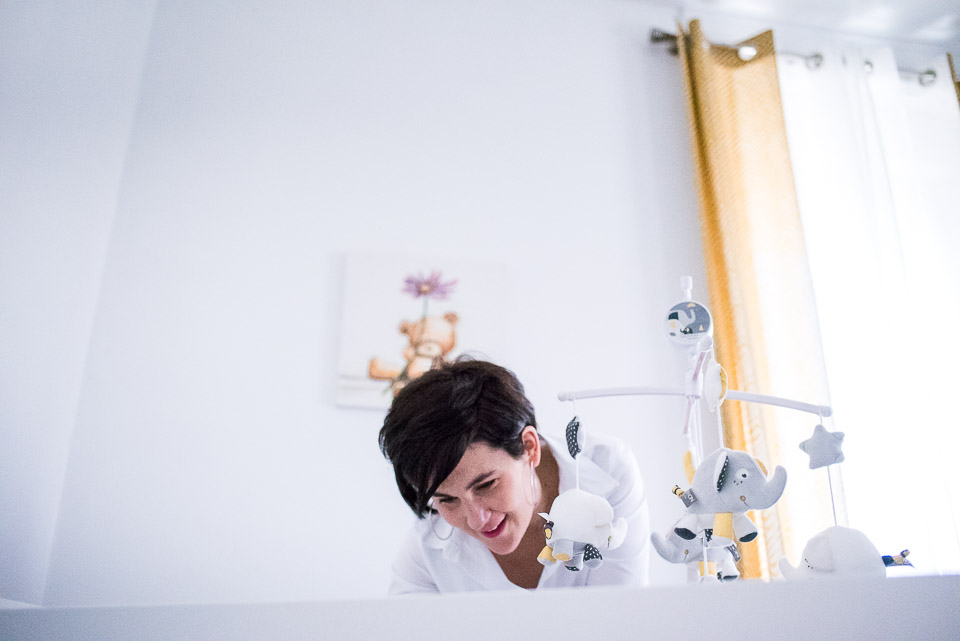 maman se penche sur le berceau de son bébé